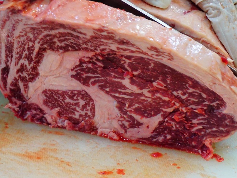 A whole cube roll being cut on a board, the marbling across the face